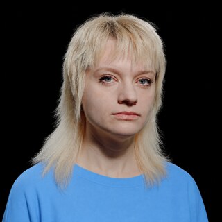 AI-generated portrait of Amanda Askell wearing a DoomBench-blue top against a black background.