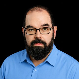 AI-generated portrait of Eliezer Yudkowsky wearing a DoomBench-blue top against a black background.