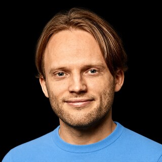 AI-generated portrait of Jan Leike wearing a DoomBench-blue top against a black background.