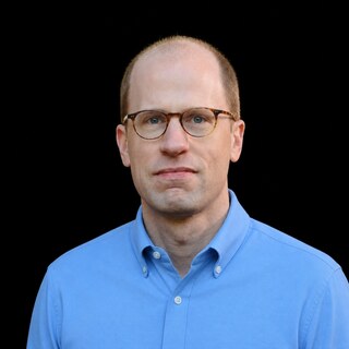 AI-generated portrait of Nick Bostrom wearing a DoomBench-blue top against a black background.